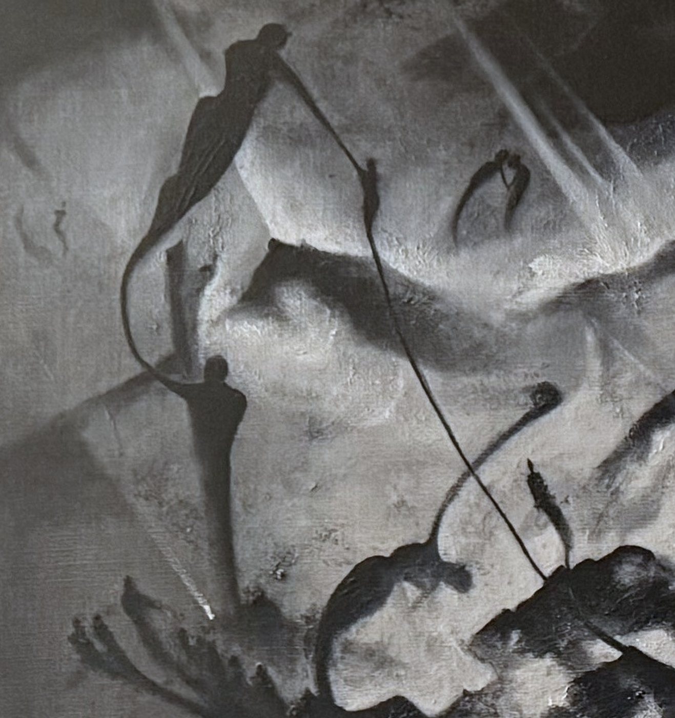 Figures hanging from thin lines above the mountain ridges